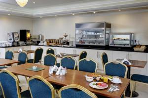 a dining room with a table and chairs and a kitchen at Best Western London Highbury in London