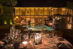 a table with wine glasses on it with a pool at Hacienda Ucazanaztacua in Pátzcuaro