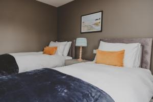 two beds sitting next to each other in a bedroom at The Butterleigh Inn in Cullompton