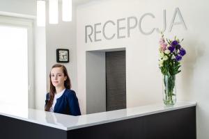 a woman sitting at a counter in front of a mirror at Avion Hotel in Świdnik