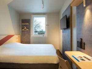 a room with a bed and a table and a window at ibis budget Antony Massy rénové 2024 in Antony