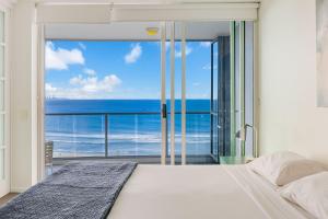 Un dormitorio con una cama y vista al mar. en Reflections On The Sea Unit 1501, en Gold Coast