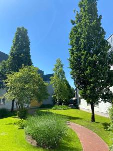 een tuin met bomen en een bakstenen pad bij Median Hotel Hannover Lehrte in Lehrte