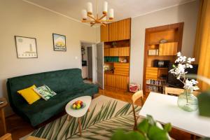a living room with a green couch and a table at Nadmorski Apartament w Orłowie in Gdynia