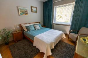 a bedroom with a bed and a chair and a window at Nadmorski Apartament w Orłowie in Gdynia