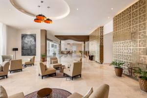 eine Lobby eines Hotels mit Stühlen und Tischen in der Unterkunft Levatio Suites Muscat, a member of Radisson Individuals in Muscat