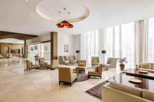 a large living room with chairs and a table at Levatio Suites Muscat, a member of Radisson Individuals in Muscat