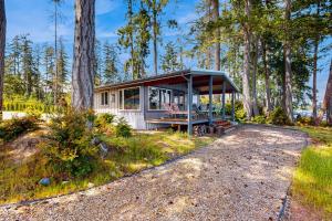 Fox IslandPoint Hope Perch的树林中的一个小房子,有门廊