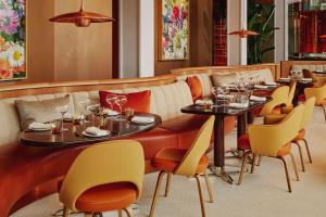 un restaurante con 2 mesas y sillas amarillas en The Emory en Londres
