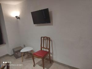 a room with a chair and a tv on a wall at Charmante maison de village cessenon sur Orb in Cessenon