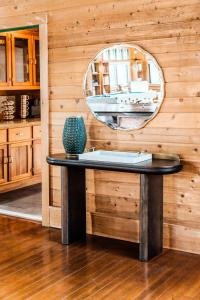 a table with a mirror on a wooden wall at Stunning Couples Retreat Lodge in Milford
