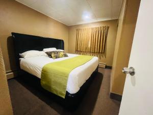 ein Schlafzimmer mit einem großen Bett und einem Fenster in der Unterkunft Travelodge by Wyndham Moose Jaw in Moose Jaw
