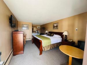 ein Hotelzimmer mit einem Bett und einem Tisch in der Unterkunft Travelodge by Wyndham Moose Jaw in Moose Jaw