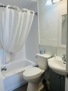 a white bathroom with a toilet and a sink at Travelodge by Wyndham Moose Jaw in Moose Jaw