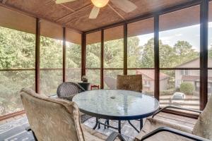 海伦Spacious Rustic Helen Abode about half Mi From Tubing!的门廊上设有玻璃桌和椅子,