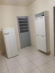 a kitchen with two refrigerators in a room at Casa da Milena in Carrancas