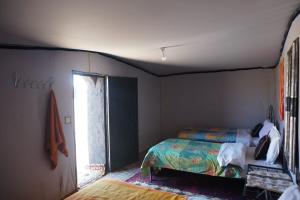 a bedroom with a bed and a window at Mhamid Tours in Mhamid