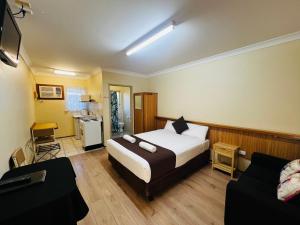 ein Hotelzimmer mit einem Bett und einer Küche in der Unterkunft Angel's Rest Motel in Moree