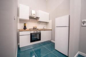 a kitchen with white cabinets and a blue floor at Palazzo De Gregorio Elegance Apartment in SantʼAntonio Abate