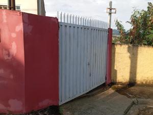 einen weißen Zaun mit einer roten Tür neben einer Wand in der Unterkunft Casa Bela Vista in Socorro
