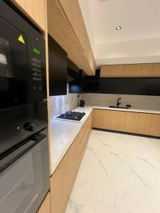 a kitchen with a stove top oven next to a sink at فيلا روبي in Buraydah