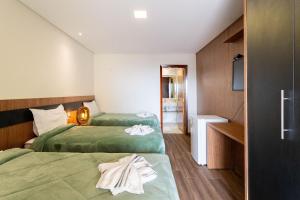 2 letti in camera d'albergo con asciugamani di Pousada Cantareira a Mairiporã