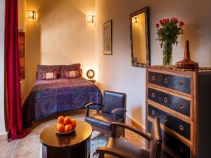 ein Schlafzimmer mit einem Bett und einer Obstschale auf einem Tisch in der Unterkunft Riad Darhani in Marrakesch