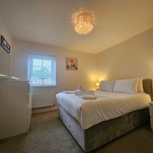 a bedroom with a large bed and a window at Modern Comfy 3 Bed Home - Free 2 space driveway and free road parking in Derby