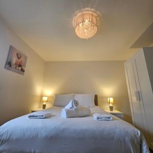 a bedroom with a large bed with towels on it at Modern Comfy 3 Bed Home - Free 2 space driveway and free road parking in Derby