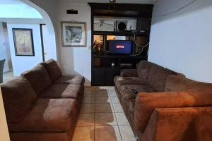 ein Wohnzimmer mit 2 Sofas und einem TV in der Unterkunft Casa en Mexicali in Mexicali