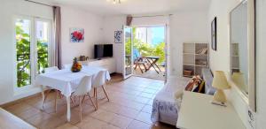 ein Wohnzimmer mit einem Tisch und ein Zimmer mit einem Balkon in der Unterkunft Apartments Marino in Drvenik