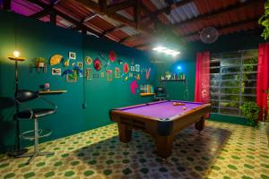 a room with a purple pool table in it at Amaranto Hostel in Panajachel