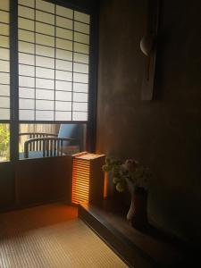 una habitación con una mesa y un jarrón con una planta en Azukiya, en Kioto