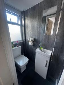 La salle de bains est pourvue de toilettes, d'un lavabo et d'une fenêtre. dans l'établissement Enjoy the comfort at beautiful studio, à Luton