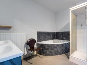 La salle de bains est pourvue d'une baignoire, d'une chaise et d'un lavabo. dans l'établissement Het Bruegelhof, à Peer