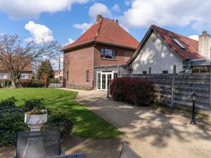 una casa de ladrillo con una valla y un patio en Het Bruegelhof en Peer