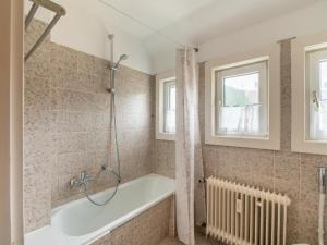uma casa de banho com uma banheira e uma janela em Kurhaus am Nordenau em Schmallenberg