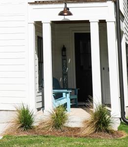 a porch with a blue bench on a house at 5 Star 4/3 sleeps 16 with Arcade GAME ROOM & POOL! in Orange Beach