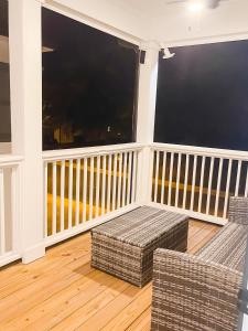 balcón con 2 sillas de mimbre y 2 ventanas en 5 Star 4/3 sleeps 16 with Arcade GAME ROOM & POOL! en Orange Beach