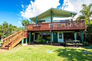 een huis met een balkon en een terras bij Backpackers Vacation Inn and Plantation Village in Pupukea