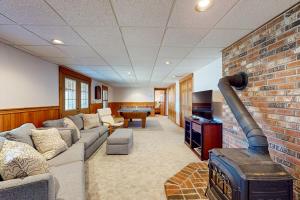 a living room with a couch and a brick wall at Summit Solitude in Franconia