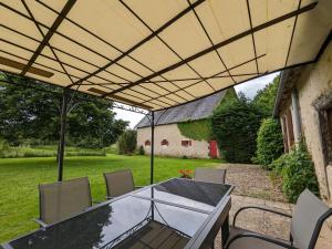 eine Terrasse mit Tisch und Stühlen und ein Gebäude in der Unterkunft Charmante maison restaurée avec jardin, étang privé et terrasse au cœur du Berry - FR-1-591-11 in Bélâbre + 12 Fotos
