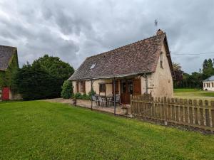 ein kleines Haus mit einem Holzzaun im Hof in der Unterkunft Charmante maison restaurée avec jardin, étang privé et terrasse au cœur du Berry - FR-1-591-11 in Bélâbre