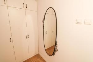 a mirror hanging on a wall next to white cabinets at Apartments by the sea Baska, Krk - 19524 in Baška