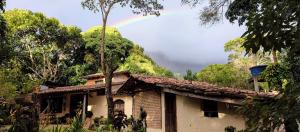 a rainbow in the sky above a house at Quarto privativo no Quintal dos Sonhos in Palmeiras