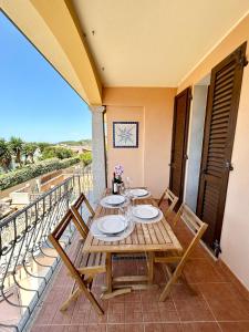 a table on the balcony of a house at Il tramonto tra Alghero e Stintino in Palmadula