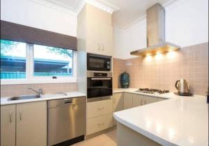 a kitchen with a sink and a stove top oven at Cheerful 3 bedroom home in the centre of town in Shepparton