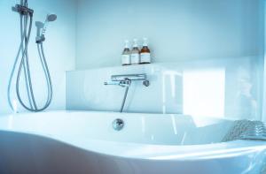 a white bath tub with a shower in a bathroom at Black Diamond 宮古島 in Karimata