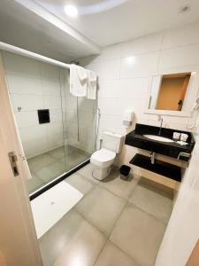 ein Bad mit einer Dusche, einem WC und einem Waschbecken in der Unterkunft Athos Hotel in Teresópolis