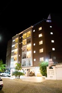 ein Gebäude in der Nacht mit davor geparkt in der Unterkunft Athos Hotel in Teresópolis